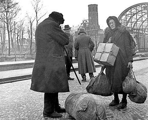 Ein Flüchtlingsehepaar wartet mit seinem Gepäck auf dem Kieler Hauptbahnhof, 31. Januar 1946.
